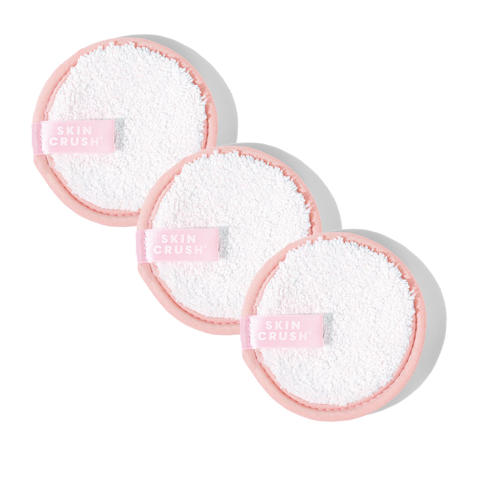 skin crush face pads white and pink makeup remover pads skin crush logo on tags on white background with sunny shadows